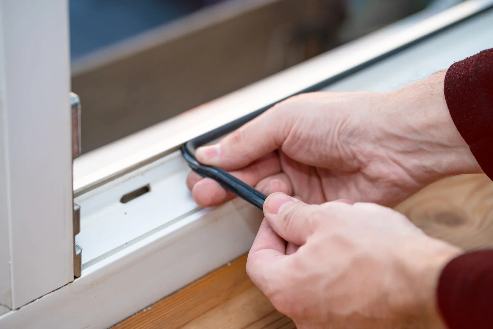 Professional technician replacing rubber gasket seal on window frame with precision